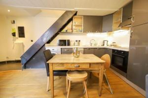 安锡La maison verte的厨房配有木桌、椅子和楼梯