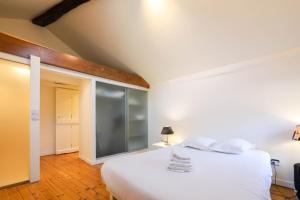 安锡La maison verte的卧室配有白色的玻璃墙床