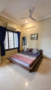 罗纳瓦拉Mystic Dreamville 3BHK Villa Lonavala的一间卧室配有一张带蓝色窗帘的大床
