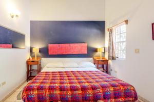 圣伊格纳西奥Framadani Villas Gold Standard Certified的一间卧室配有一张大床和色彩缤纷的毯子