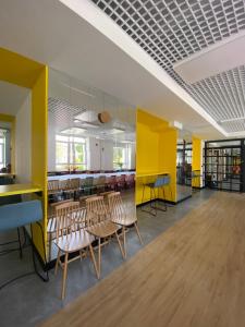兰卡特Zespół Placówek Oświatowych - Bursa的配有桌椅和黄色墙壁的客房