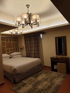 艾因苏赫纳Porto El Sokhna Pyramids 2的一间卧室配有一张大床和一个吊灯。