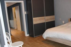 Comblain-au-PontGite Du bac的卧室配有1张床、1张桌子和1把椅子