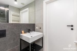 科沃布热格GreenPort Apartamenty Kołobrzeg - Dining & SPA的浴室设有白色水槽和镜子