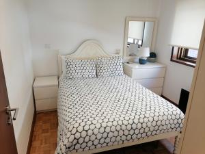 波瓦-迪瓦尔津Beach House的一间卧室配有一张带白色床罩和镜子的床