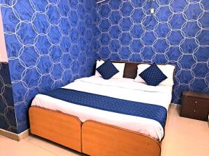 新德里Atlas Inn Guest House的蓝色墙壁间的一张床位
