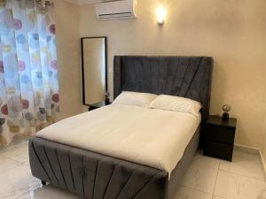 弗里敦After 5 Apartment 1- 3 spacious en-suite bedrooms的一间卧室配有一张大床和黑色床头板