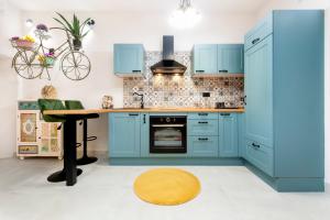 罗维尼Apartman Paulina的厨房配有蓝色橱柜和木桌