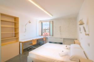 威尼斯Combo Venezia的一间卧室配有一张床、一张书桌和一个窗户。
