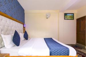 马拉里FabHotel Negis Shivalay的酒店客房的床铺配有蓝色和白色的床单