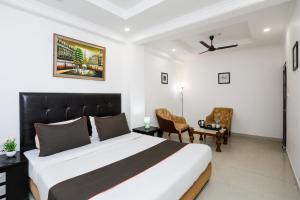新德里Collection O Hotel Residency Near Dwarka Sector 21 Metro Station的卧室配有一张床、一张桌子和椅子