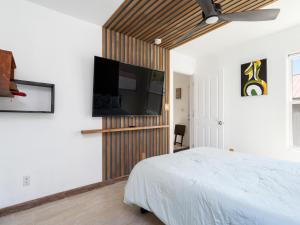 圣达菲Return House的一间卧室配有一张床和一台平面电视