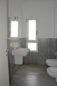 萨尔雷BoaOp Apartaments的浴室设有2个盥洗盆、卫生间和2面镜子。