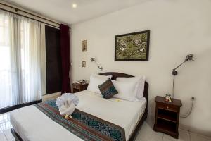 沙努尔Manzelejepun Luxury Villa & Pavilion的一间卧室设有床、两张桌子和一扇窗户