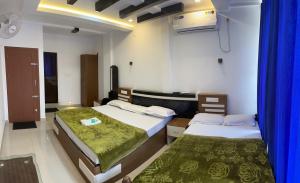 ThirunelliDakshinakasi Guest House的配有蓝色窗帘的客房内的两张床