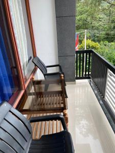 ThirunelliDakshinakasi Guest House的两把椅子坐在房子的阳台上