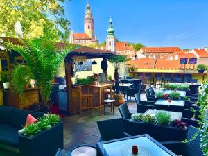 捷克克鲁姆洛夫阿卡迪公寓酒店的屋顶庭院设有桌椅和植物