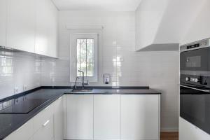 金塔湖Vilar do Golf的白色的厨房配有白色橱柜和水槽