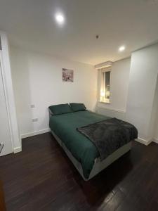 巴塞尔顿Amazing 1 Bedroom Flat in Essex TH104的一间卧室配有一张带绿色棉被的床和窗户。