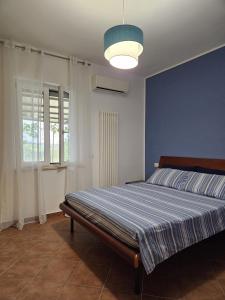 PianellaCasa vacanze La Castellana的一间卧室配有一张蓝色墙壁的床