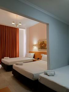 里约热内卢Hotel Atlântico Tower的酒店客房设有三张床和窗户。