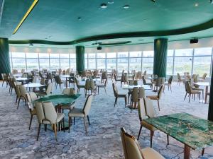 澳门YOHO Treasure Island Hotel的用餐室设有桌椅和窗户。