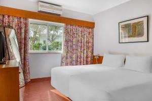 金塔湖Vilar do Golf的卧室配有白色的床和窗户。