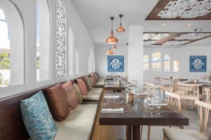 贝纳尔马德纳Sahara Sunset的用餐室设有桌椅和窗户。