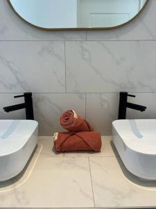 威廉斯塔德Villa Sol A Luna - Mambo Beach的浴室设有两个水槽,中间有一条红色毛巾