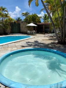 圣若泽-达科罗阿格兰迪Village do Sossego的棕榈树庭院里的一个大型蓝色游泳池