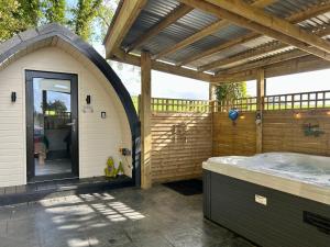 BurnfootPaddock Pod - Sleeps 4 & Roofed Over Private Hot Tub的一座带凉棚的建筑中的露天热水浴池