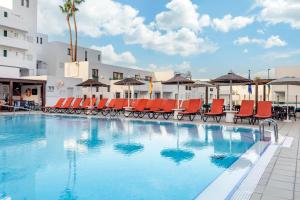 阿德耶日落湾俱乐部钻石度假公寓的一个带椅子和遮阳伞的大型游泳池