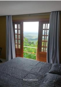 贝泽罗斯Refúgio Serra Negra - PE的一间卧室设有一张床和一个大窗户