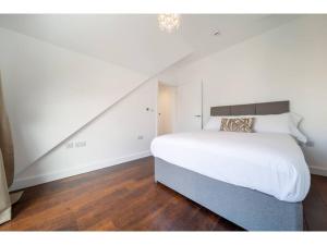 纽基Gwel An Keynvor Penthouse的卧室设有一张白色大床和楼梯。