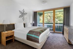 斯拉德明钻石度假村阿尔卑斯俱乐部酒店的卧室设有一张白色大床和一扇窗户。