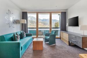 斯拉德明钻石度假村阿尔卑斯俱乐部酒店的客厅配有蓝色的沙发和电视