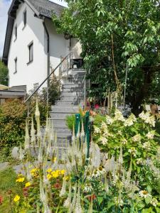 开姆尼茨Wildes Paradies,135 qm Ferienwohnung im Naturgarten的一座鲜花盛开的花园,房子前面有楼梯