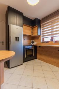 武科瓦尔Dobro Došli Vukovar的厨房配有不锈钢冰箱和木制橱柜