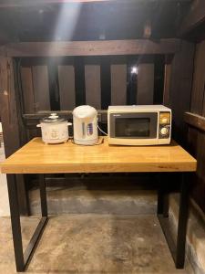 清迈Grandma’s House的一张木桌,配有微波炉和慢煮器