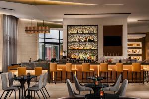 凤凰城AC Hotel by Marriott Phoenix Downtown的一间带桌椅的餐厅和一间酒吧