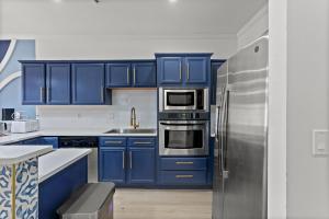 默特尔比奇Luxurious Home with Theatre Room的厨房配有蓝色橱柜和不锈钢冰箱