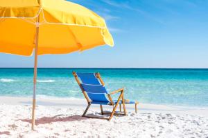 德斯坦桑德斯丁海滩希尔顿高尔夫Spa度假酒店的海滩上的沙滩椅和遮阳伞