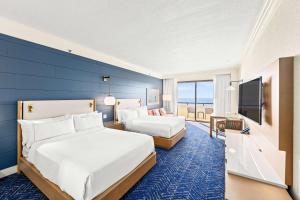 德斯坦桑德斯丁海滩希尔顿高尔夫Spa度假酒店的酒店客房设有两张床和蓝色的墙壁。