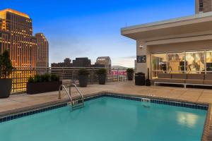 新奥尔良新奥尔良法国区/中央商圈希尔顿花园酒店的一座城市天际线建筑的顶部游泳池