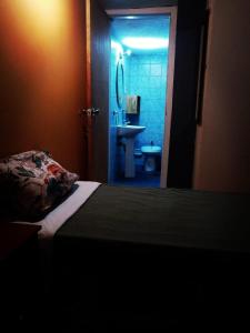 蒙得维的亚Patio Urbano Suites & beds的一间卧室配有一张床,浴室设有水槽