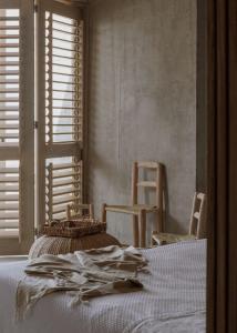 锡瓦塔塔内霍Casa_Paki的一间卧室配有一张带两把椅子的床和一扇窗户