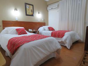 雷孔基斯塔Grand Hotel的酒店客房带两张红色和白色的床单