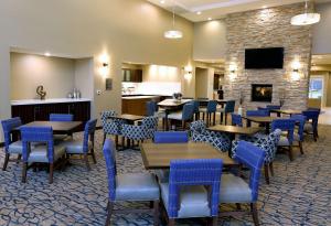 法戈Homewood Suites By Hilton West Fargo/Sanford Medical Center的一间带桌椅和壁炉的餐厅