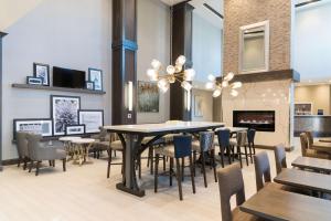 印第安纳波利斯Hampton Inn & Suites Indianapolis-Keystone, IN的一间带桌椅和壁炉的用餐室