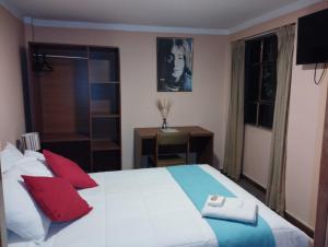 普诺Huaytusive Inn Hotel的卧室配有带红色枕头的大型白色床